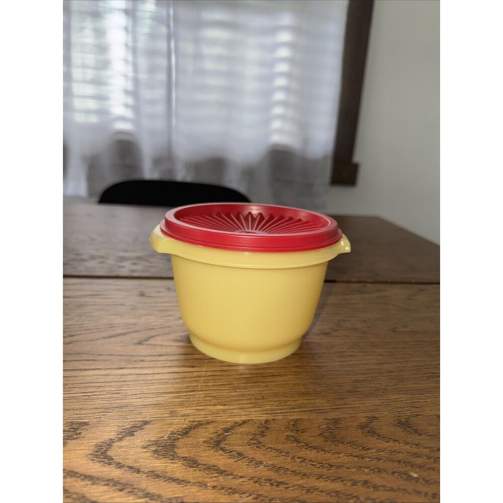 Vintage Tupperware Servalier bowl in yellow with a red starburst lid
